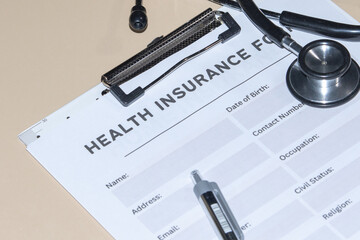 A health insurance application form set on a desk with a stethoscope, illustrating medical coverage and patient protection.