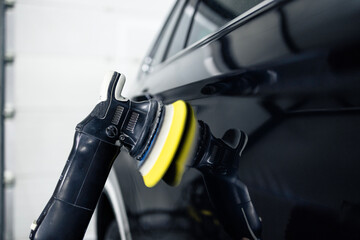 Close up view of polishing grinder working on a car body.