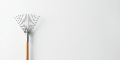 A sleek, metal-tined leaf rake with a light wood handle against a plain white background