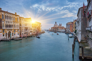 Old canal with bridge, gondola, houses, flowers in cloudy weather. Venice