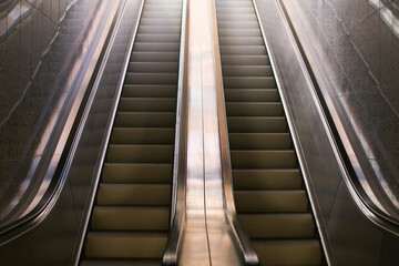 Modern underground architecture background. Escalators leading to a train platform. Pedestrian walkway. Subway passageway. Airport or trainstation escalator. Urba city landscape.