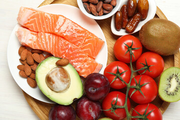Different products rich in serotonin on white wooden table, top view