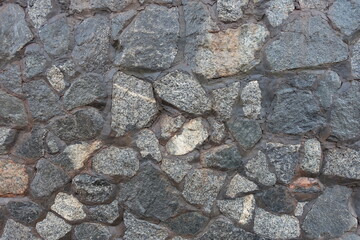 Rough surface of wall made of gray natural shape fieldstones