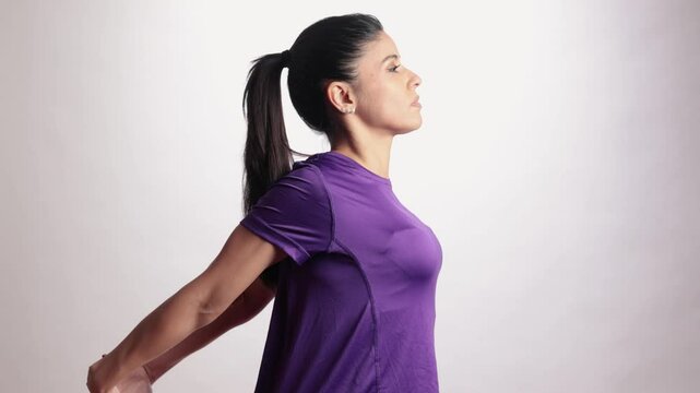 Latin woman performing slow motion neck stretching exercise on white background