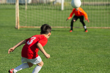 Obraz premium Young boy shooting soccer ball