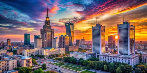 Obraz premium Warsaw's cityscape glows: modern architecture silhouetted against a vibrant pink and blue evening sky.