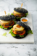 Black burgers with grilled pineapple