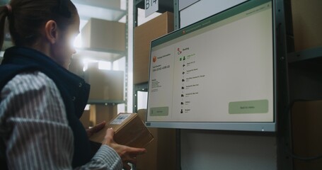 Female Logistics Manager Scans Cardboard Box at Postal Terminal with Digital Screen, Checks Delivery Information of Parcel with E-Commerce Goods Using Tracking App. Warehouse Retail Center. Dolly Shot