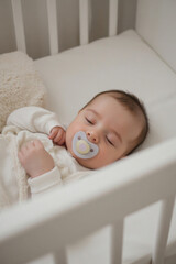 a baby sleeping peacefully in a white crib.