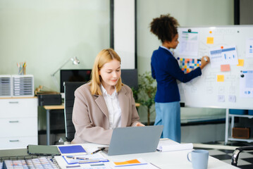 Obraz premium Businesswoman leading team meeting and using tablet and laptop computer with financial