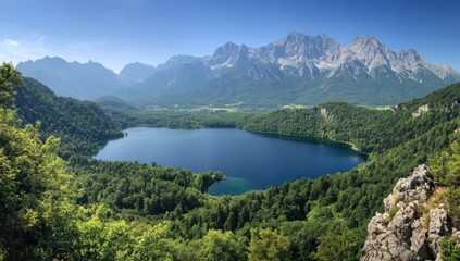 Obraz premium A serene lake reflects the bright blue sky, embraced by rolling green hills and majestic mountains. The peaceful atmosphere invites exploration and appreciation of nature's beauty
