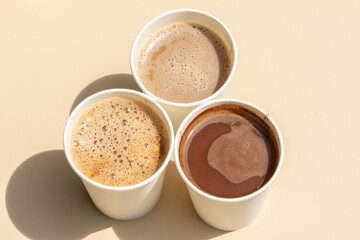 A set of takeaway coffee cups filled with various coffee drinks, from frothy to bold.