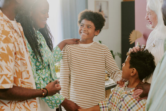 African American boy looking at his relatives and enjoying moment in family circle