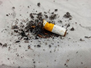 Close up of used cigarette butts on white background. Selective focus