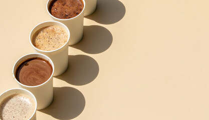 A selection of different coffee drinks served in takeaway cups, showcasing various coffee styles.