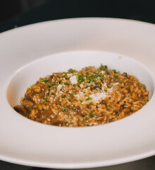 Risotto con champiñones y parmesano en plato blanco