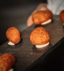 Chef making croquettes on a black background. Selective focus.
