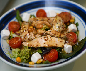 Ensalada de pollo, tomates cherry, queso griego y rúcula