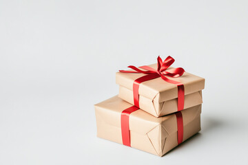 Obraz premium Gift boxes tied with red ribbons, stacked on white background. Copy space.