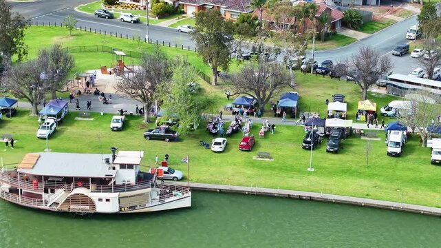 Aerial of a steamboat on the lake with a small market behind