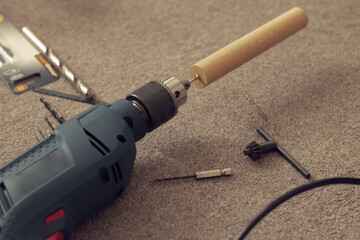 Modern electric drill on gray carpet, top view.