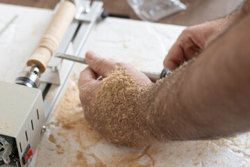 Small metal lathe machine, close-up. wooden stick rolling on the machine.