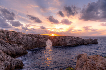 In the middle of the Mediterranean we see the beautiful natural rock arch, Pont d en Gil in Menorca...