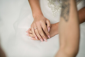 A woman is holding her hands together, with a ring on her finger. The ring is a diamond, and it is a symbol of love and commitment. Concept of warmth and affection