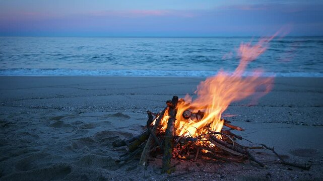 Warm flames of a campfire illuminate a peaceful sandy beach with a calm sea and soft twilight in the background. Ideal for travel, adventure, and serenity concepts