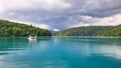 Fototapeta premium Plitvice Lakes - Croatia - June 30, 2024 People ride on an electric boat between the 12 upper and 4 lower lakes in the Plitvice Lakes National Park. Plitvice Lakes National Park in Croatia