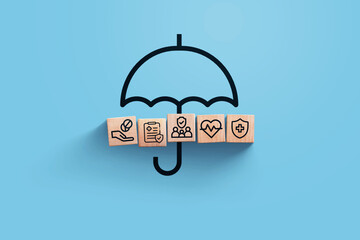 insurance, creative idea. Wooden blocks with icons of medical insurance with umbrella on blue background, top view. Health and insurance, concept © alones