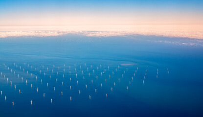 Aerial view of an offshore wind farm in English channel with numerous wind turbines in the ocean.