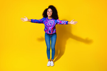 Full length photo of lovely young lady stretch hands welcome dressed stylish colorful blue garment isolated on yellow color background