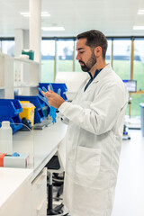 Fototapeta premium Scientist wearing blue gloves in laboratory holding test tube 