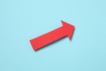 Paper arrow on color background, top view