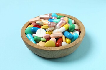 Various pills in a bowl on color background