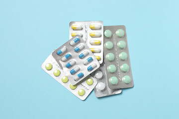 Pills in blister packs on blue background, close up