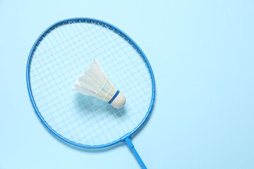 Badminton racket and white badminton shuttlecock on color background