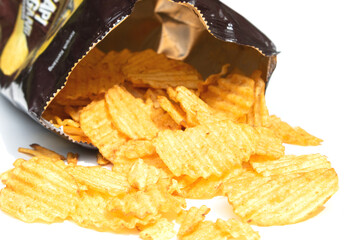 A tasty pile of potato crisps isolated on a bright white background, ideal for snack presentations.