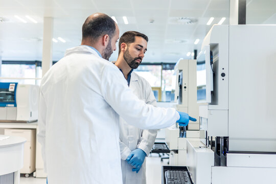 Medical laboratory technicians working with modern equipment performing blood analysis 