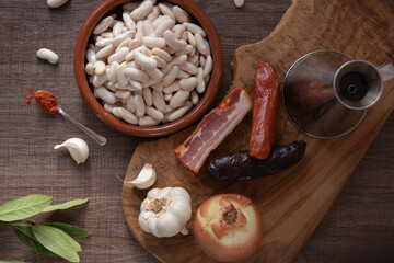 Ingredients for preparing Asturian fabada displayed on wooden table