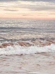 Close-up of crashing waves and foam at sunset, dynamic ocean scene.