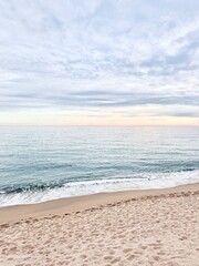 Vertical view of calm waves on the beach during sunset.