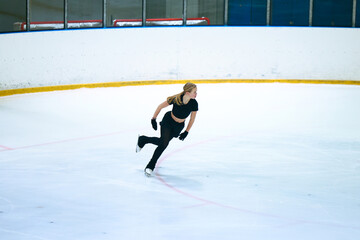 Figure skating girl training on ice arena.