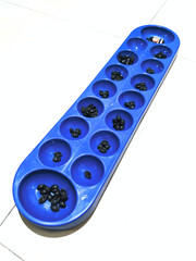 Congklak is a traditional game played on a perforated board.