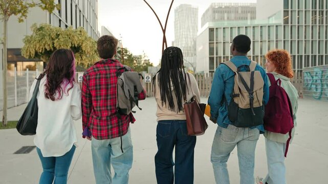 Backview of group of college students walking arriving to University to start classes