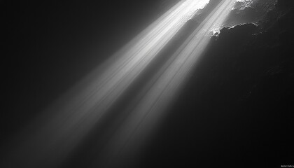 Light beams shining into dark cave, dust motes, background rock formations