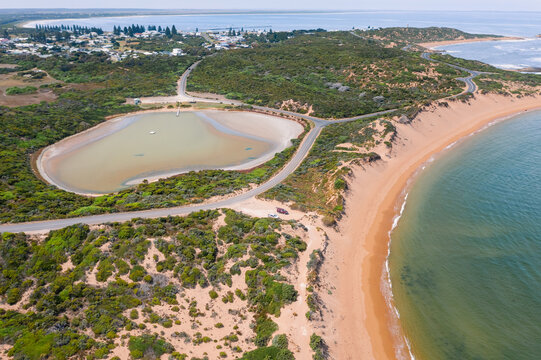 Aerial view of a salt lake circled by roads along a sandy coastline - Pool of Siloam