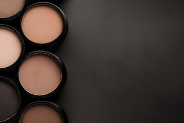 Fototapeta premium Mocha mousse, brown cosmetic powder containers arranged on dark background, top view, makeup products