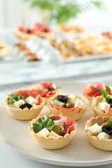 Many tasty canapes on white table, closeup